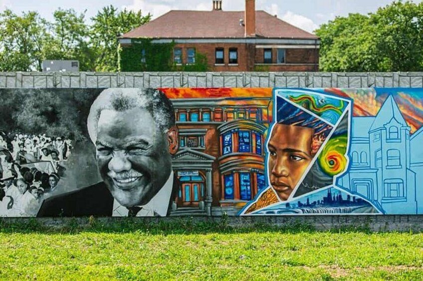 A mural with a building and a person. 2