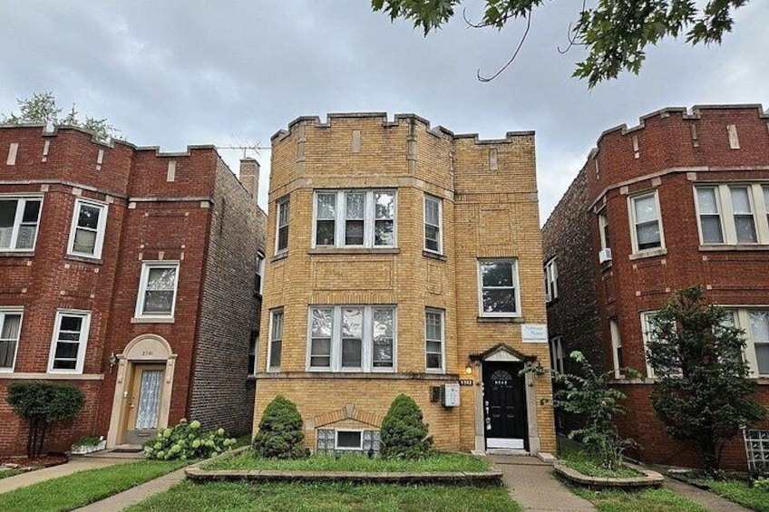 A row of red brick apartment buildings with a central yellow brick building. 2