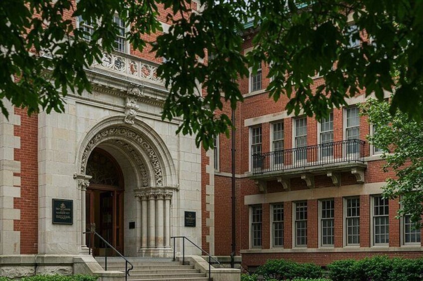 A building with a large arched entrance, brick walls, and a balcony. 1