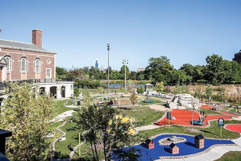 A park with a brick building, a fountain, and a red-roofed structure. 2