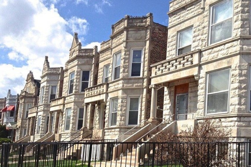A row of stone Victorian houses with prominent gabled roofs and large windows. 5