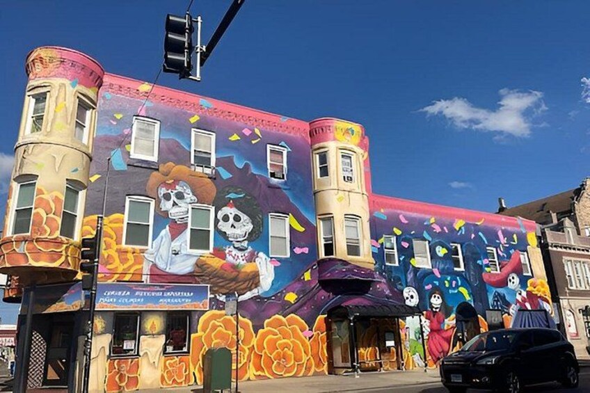 Un edificio con murales coloridos, incluyendo calaveras y flores. 3