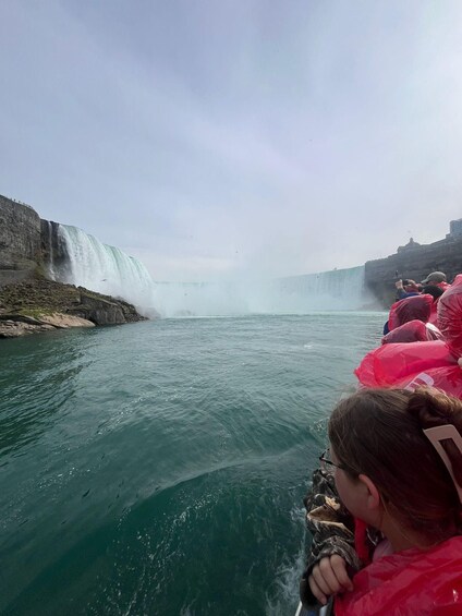 A waterfall with people on a boat in the foreground. 4