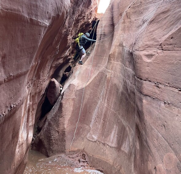 A person rappelling down a canyon wall. 5
