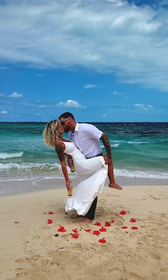 A couple embracing on a beach with the ocean in the background. 3