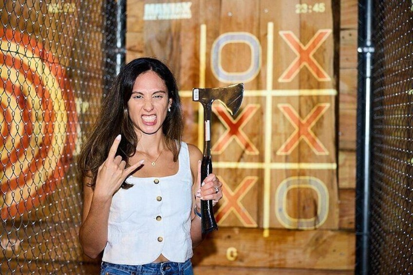 A person holding a large axe in front of a tic-tac-toe board. 1
