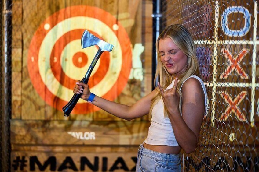 A person holding an axe in front of a target with a bullseye. 3