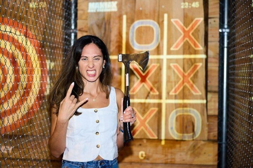 A person holding a hammer in front of a tic-tac-toe board. 1