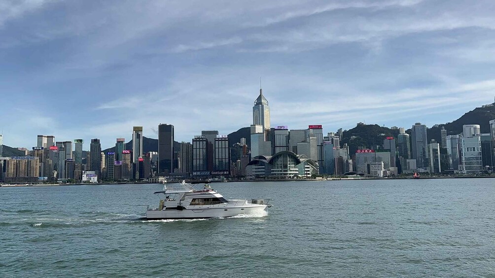 A city skyline with a prominent skyscraper, a body of water, and a yacht. 3