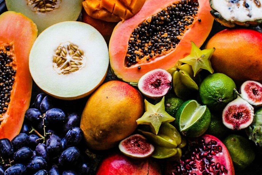 A variety of fresh fruits including papaya, mango, grapes, figs, and starfruit. 5