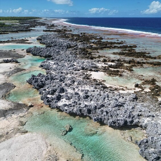 A coastal landscape with rocky formations, clear turquoise waters, and a distant shoreline. 5