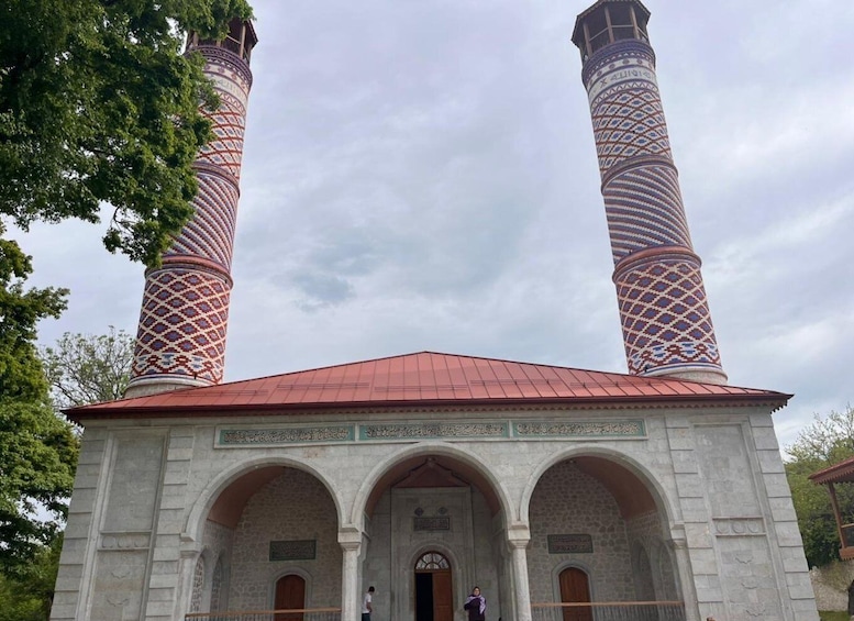 A mosque with two tall minarets and a red roof. 4