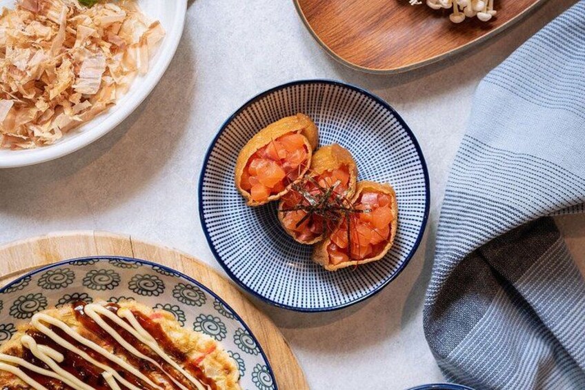 A plate of sashimi, a bowl of shredded fish, and a plate with a sauce drizzle. 2