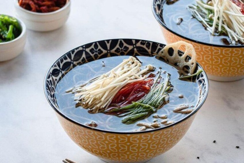 Un bol de soupe contenant divers légumes et des nouilles. 2