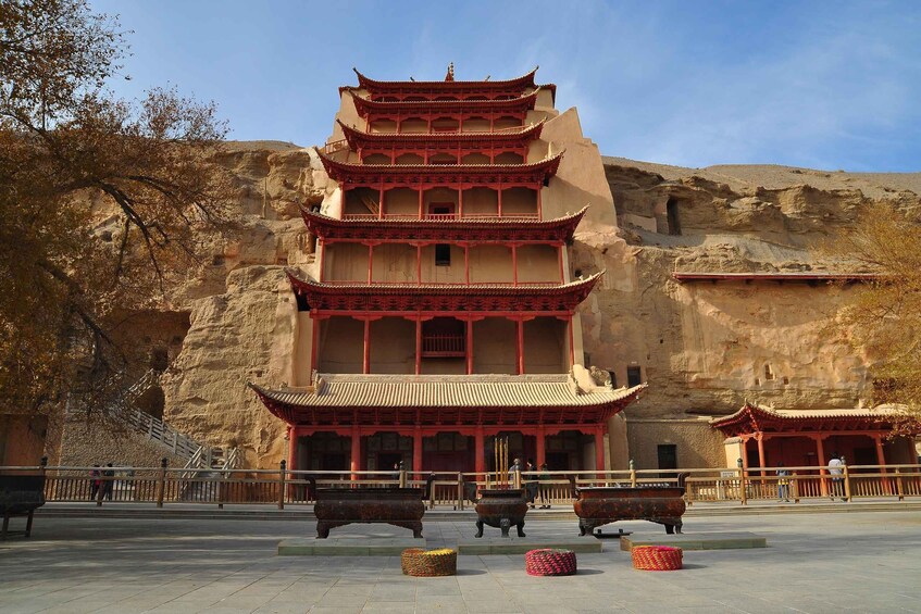 A multi-tiered pagoda with traditional architecture, set against a rocky backdrop. 1