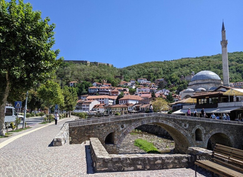 A stone bridge, historic buildings, and a mosque with a minaret. 1