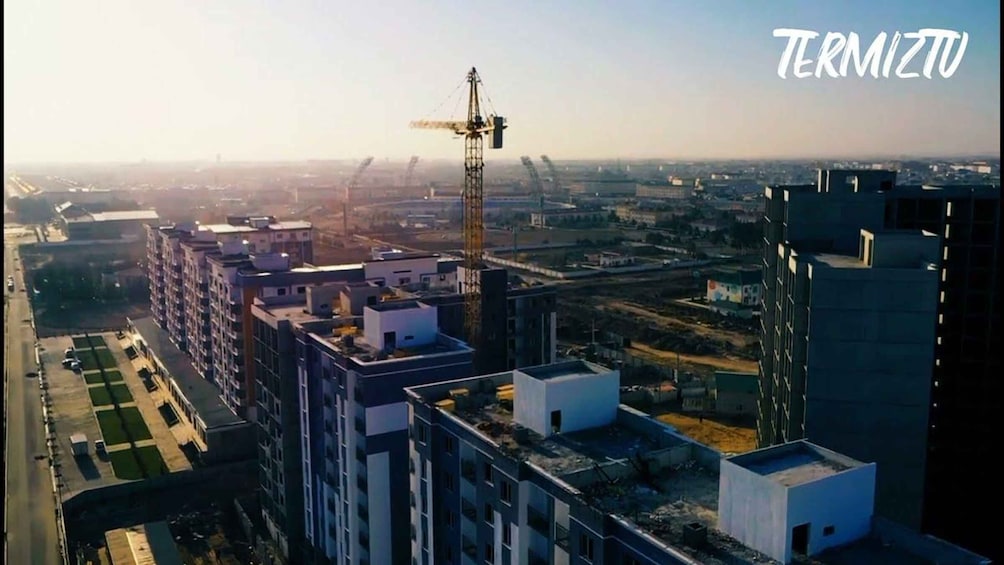 A construction site with a crane, buildings, and a clear sky. 2