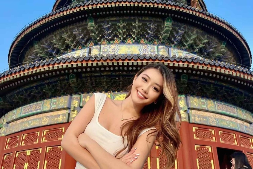 A person standing in front of a traditional Chinese building with ornate roof tiles and intricate designs. 3