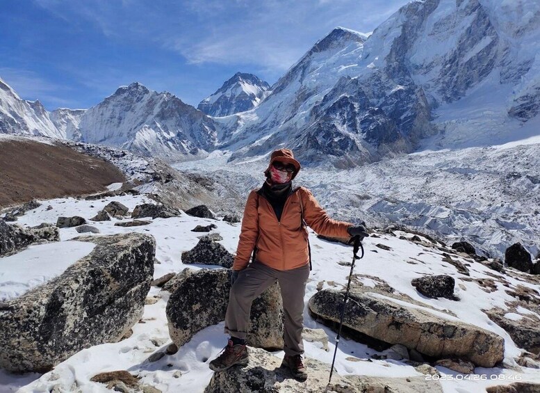A hiker in a mountainous snowy landscape with rocky terrain and snow-covered peaks. 4