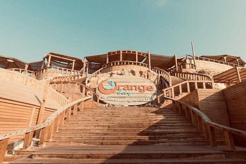 Holztreppe zu einem Schild mit dem Wort 'Orange' und einem Logo. 5