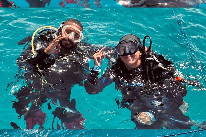 Zwei Personen in Tauchausrüstung unter Wasser in einem Schwimmbecken. 3
