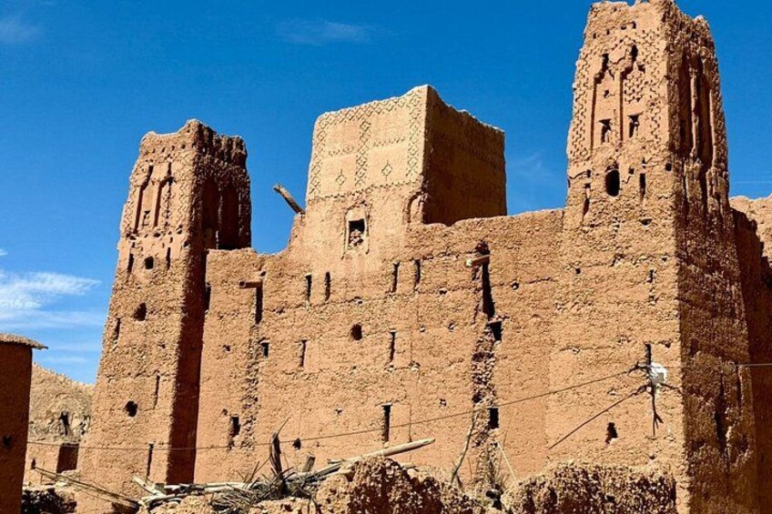 A large, ancient brick structure with multiple towers and a flat roof. 2