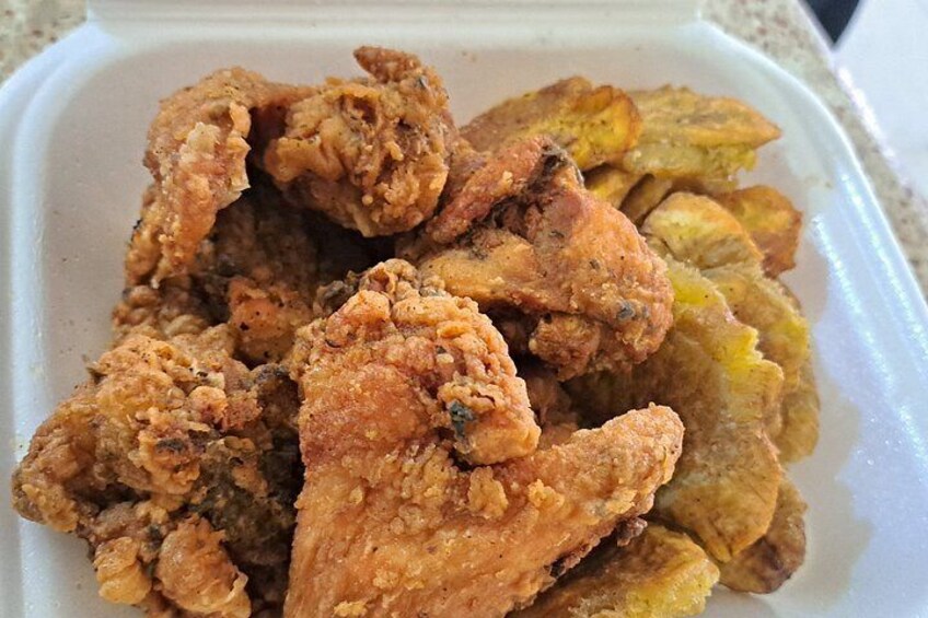A container of fried chicken and fried plantains. 2