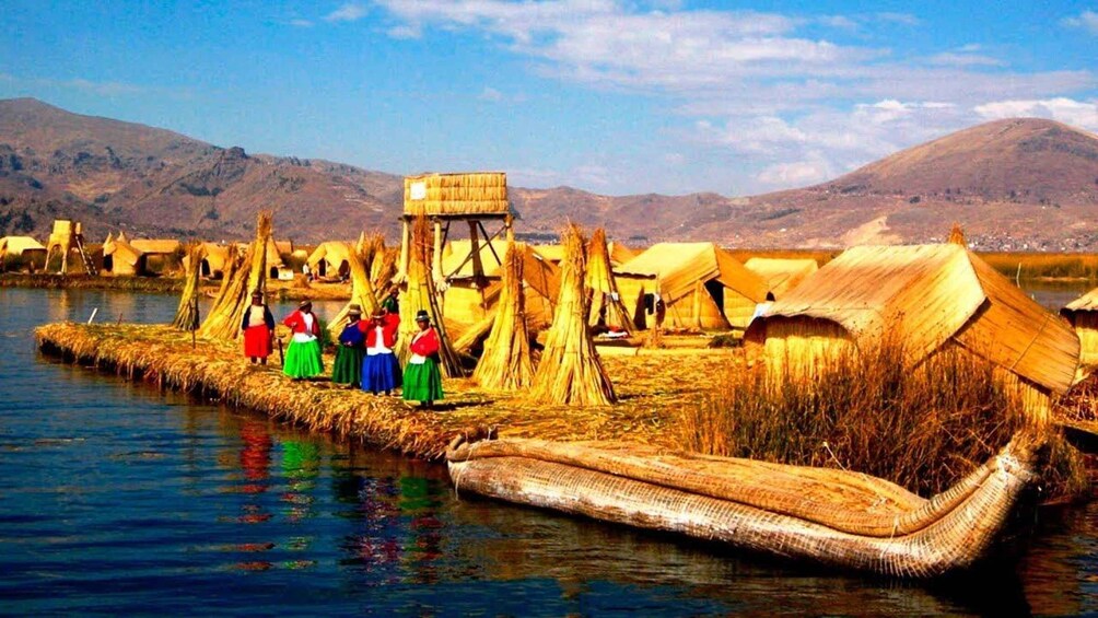 A traditional floating village with thatched huts and people in colorful attire. 5