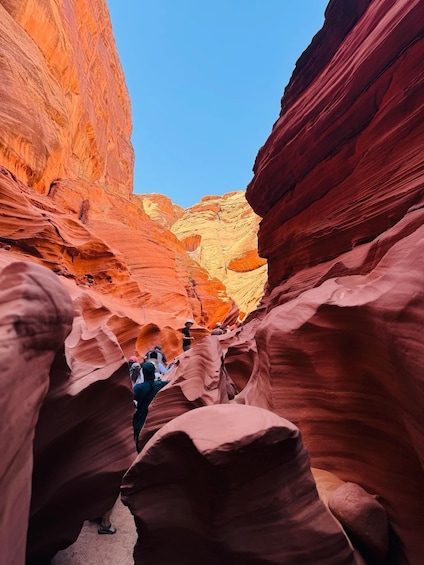 A canyon with red sandstone walls and a clear blue sky. 2