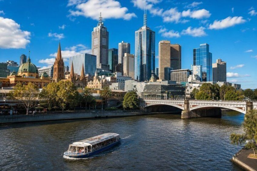 A river with a boat, a bridge, and a city skyline with historic and modern buildings. 2