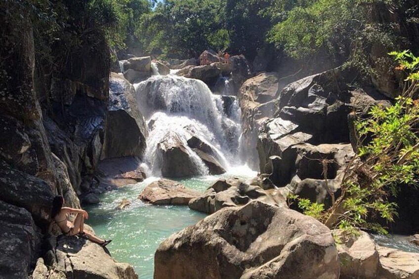 Una cascada que cae sobre rocas en un área boscosa. 1