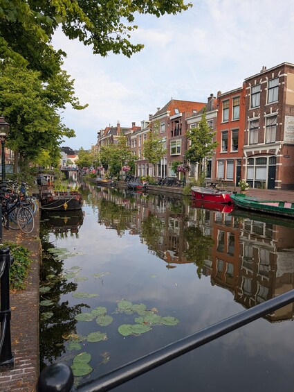 A canal with boats, bicycles, and traditional buildings reflecting on the water. 5