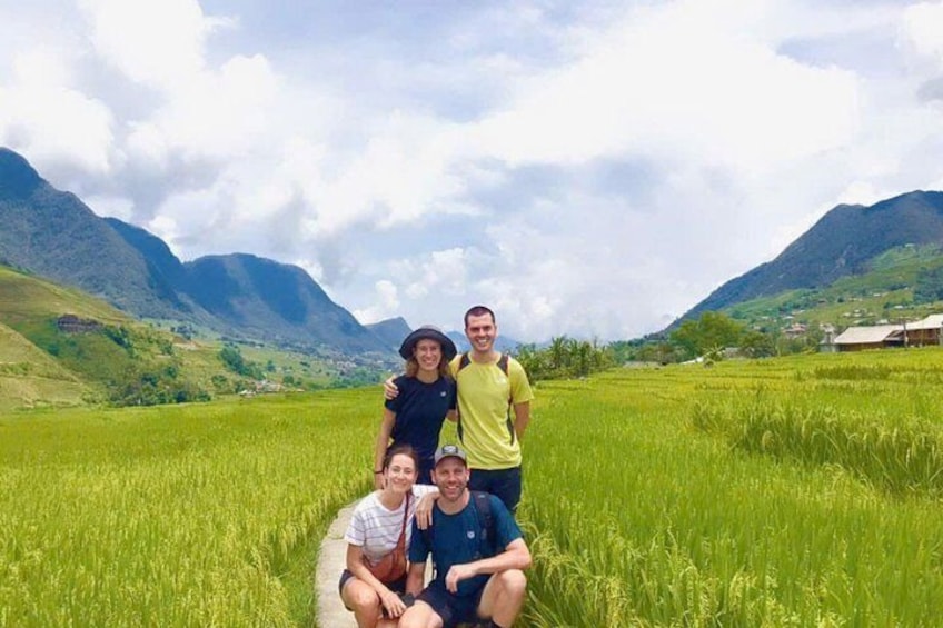 Eine Familie in einem grünen Feld, im Hintergrund Berge. 1