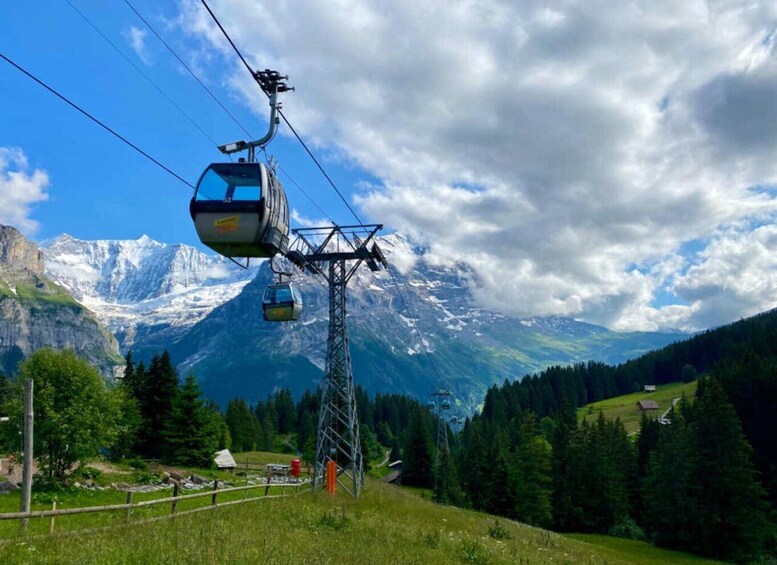 A cable car system in a mountainous area with snow-capped peaks in the background. 4