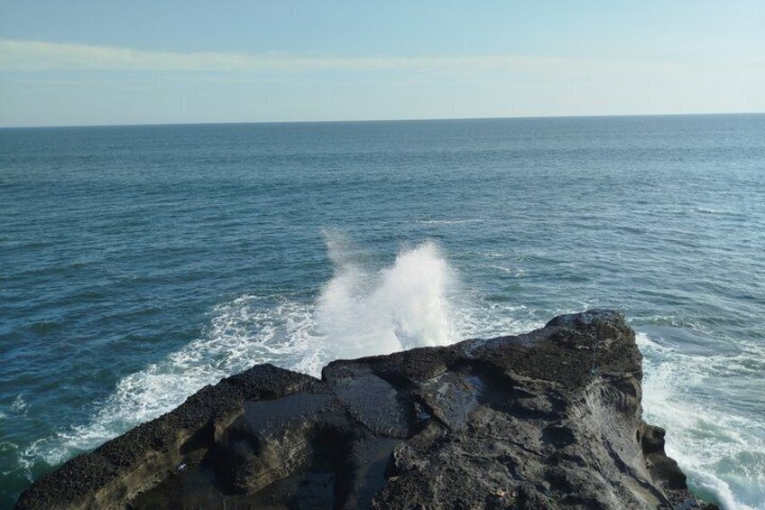 A rocky coastline with waves crashing against it. 5