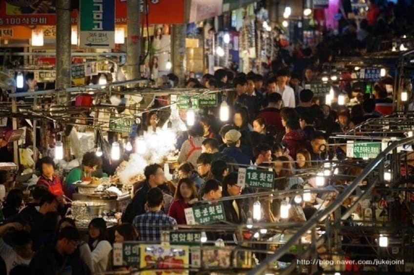 A crowded night market with stalls and people. 2