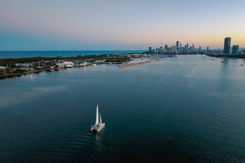 A sailboat on calm waters with a city skyline in the background. 3