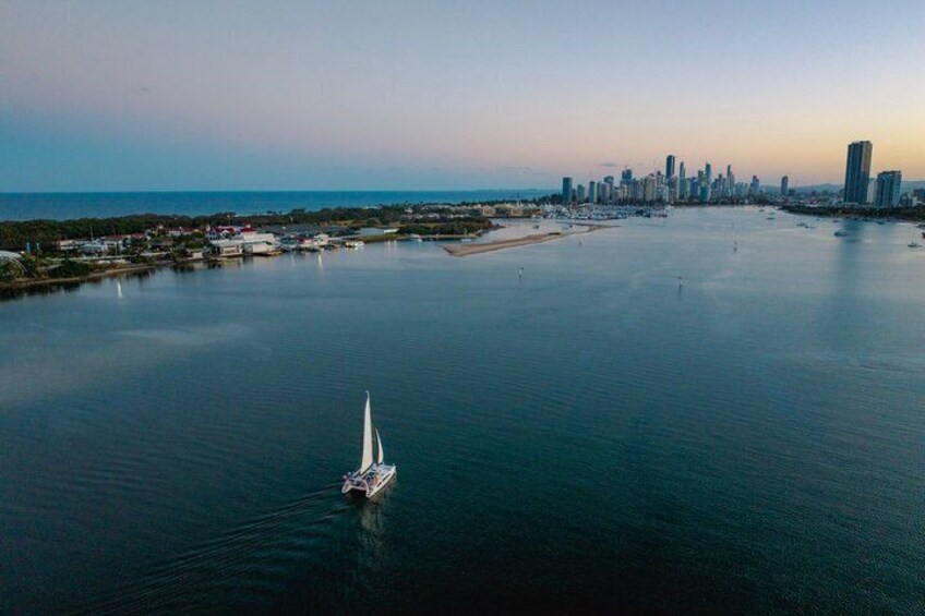 A sailboat on calm waters with a city skyline in the background. 3