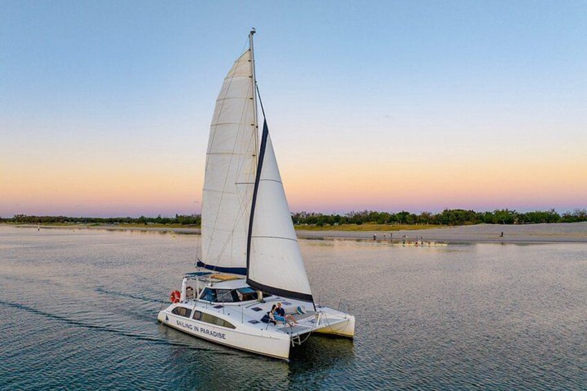 A sailboat named 'Sailing in Paradise' on calm water with a clear sky. 3
