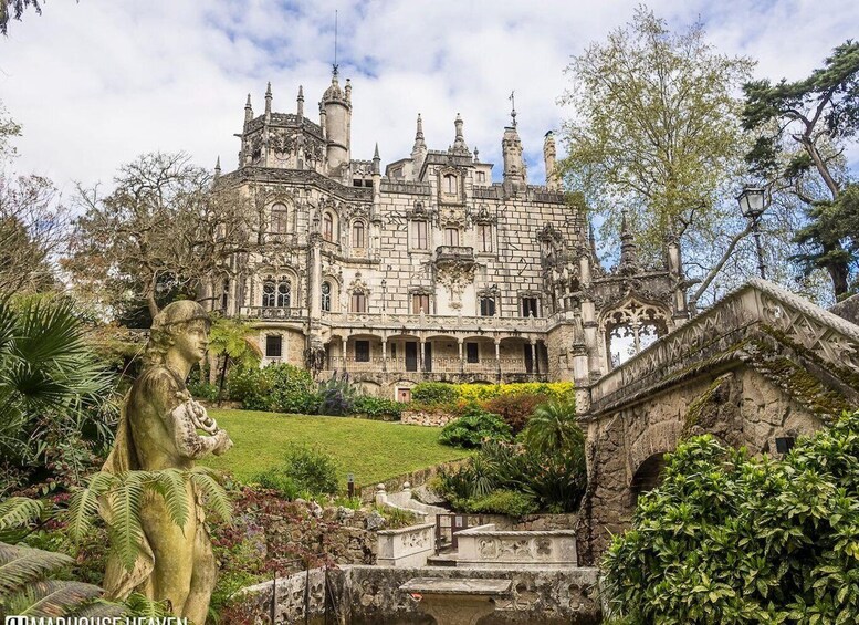 A Gothic-style castle with intricate architecture, a statue, and lush greenery. 3