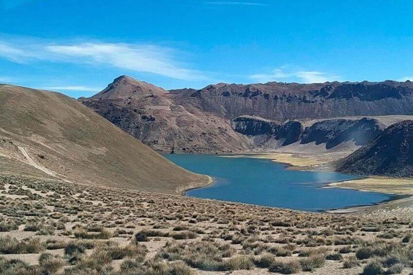 A desert landscape with a lake, mountains, and sparse vegetation. 3