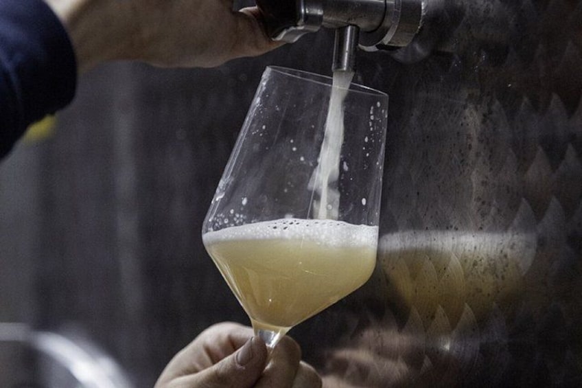 A hand holding a glass under a tap, with liquid being poured into it. 2