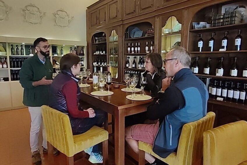 A group of people seated at a bar with wine bottles in the background. 2
