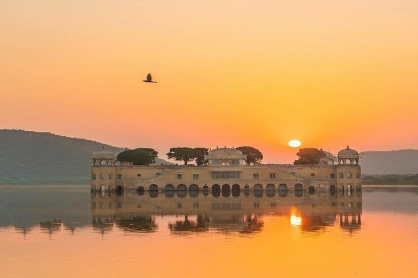 Un edificio storico con cupole e archi, riflesso in acque calme al tramonto. 4