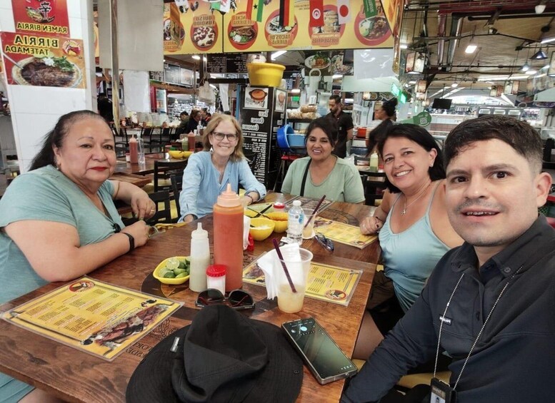 A group of people dining at a restaurant with a menu and condiments on the table. 2