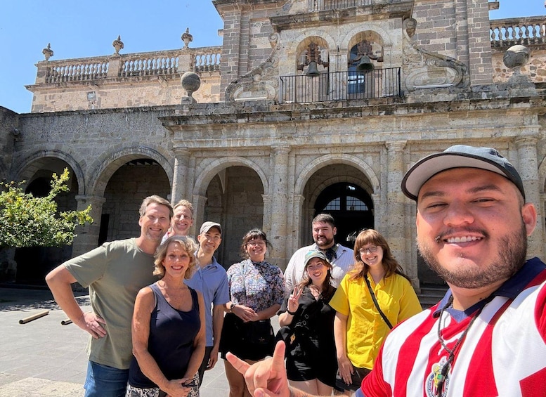 A group of people in front of a historic building with arches and decorative elements. 5