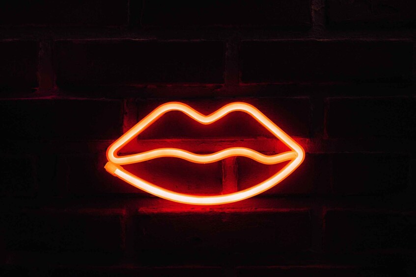 A neon-lit neon mouth against a brick wall. 3