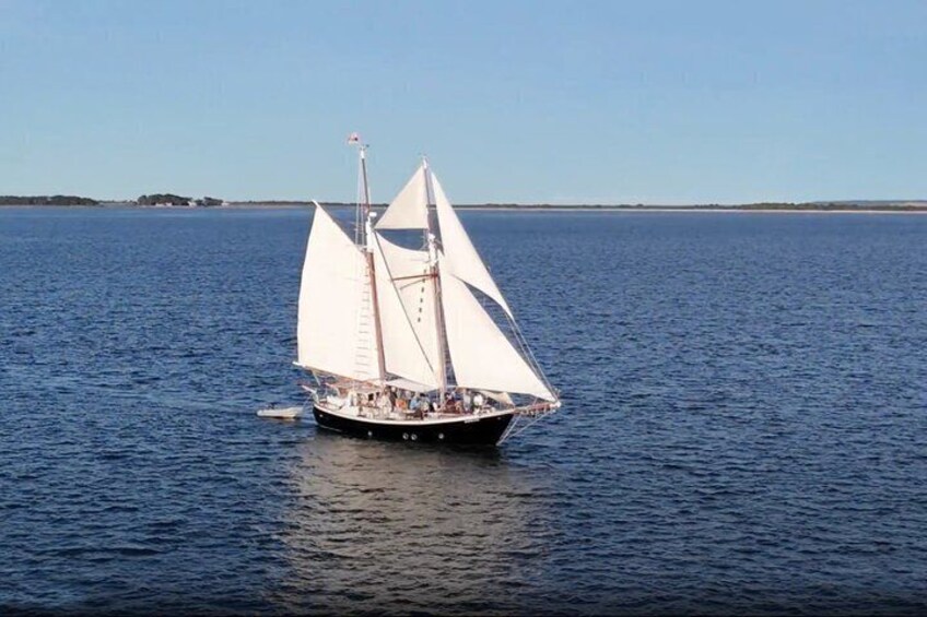 A sailboat with white sails on a calm sea. 4