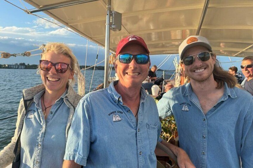 Three people on a boat with a city skyline in the background. 5