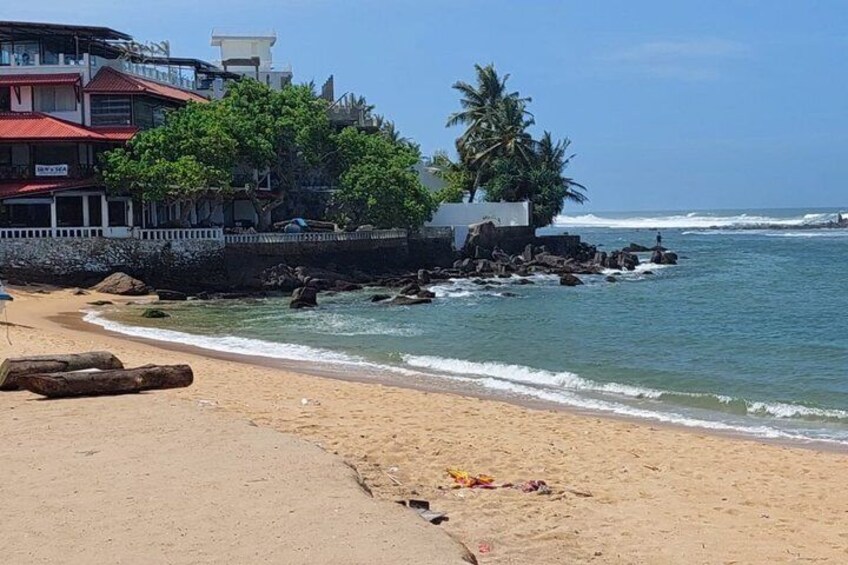 Una playa con un edificio, palmeras y olas. 2